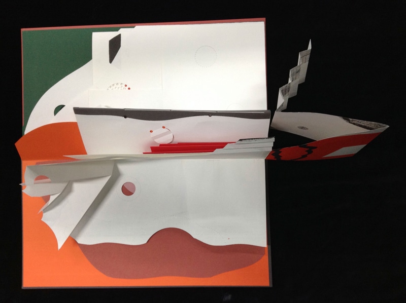 An open art book with shaped and cut coloured pages in different layers and elevations